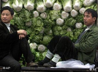 Chinese men sitting on a truckload of vegetables wait for customers at a wholesale market in Beijing, China, Saturday, Nov. 1, 2003. The U.S. administration is pressuring China to lower its trade tariffs against U.S. manufactured goods and farm products in addition to allowing U.S. banks, telecommunications companies and other service companies to compete for business in China. (AP Photo/Ng Han Guan)