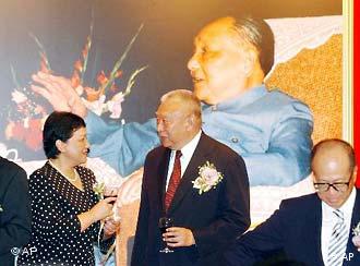 Daughter of late Chinese paramount leader Deng Xiaoping, Deng Nan, left, chats with Hong Kong leader Tung Chee-hwa in front of a portrait of her father during the opening ceremony in Hong Kong, Thursday, Aug. 26, 2004, of an exhibition marking the 100th anniversary of Deng's birth. The exhibit features pictures and personal items of Deng. At right is local tycoon Li Ka-shing. (AP Photo/Anat Givon)
