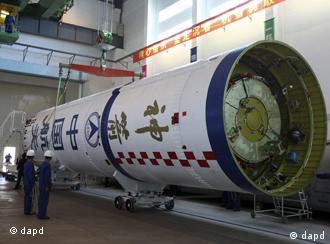 In this photo taken Sunday, Sept. 25, 2011, Chinese workers prepare the Long March 2F carrier rocket, which will launch the Shenzhou-8 unmanned spacecraft later this year into space, after the launch of the Tiangong-1 space module this week at the Jiuquan Satellite Launch Center in Jiuquan in China's Gansu province. China plans to launch the Tiangong-1 module into orbit between Sept. 27 and Sept. 30 to perform the nation's first space docking. (Foto:AP/dapd) CHINA OUT