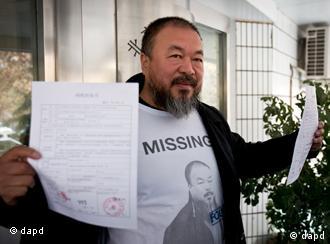 Chinese dissident artist Ai Weiwei shows his tax guarantee slips as he leaves the the Beijing Local Taxation Bureau, China, Wednesday, Nov. 16, 2011. Ai went to the local tax bureau to fill in paperwork for a $1.3 million guarantee, and told reporters he feels like he was paying a ransom. (Foto:Andy Wong/AP/dapd)