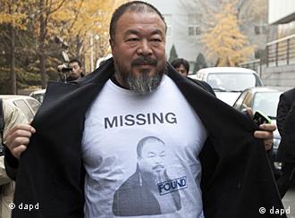 Chinese dissident artist Ai Weiwei opens his jacket to reveal a shirt bearing his portrait as he walks into the Beijing Local Taxation Bureau, China, Wednesday, Nov. 16, 2011. Ai went to the local tax bureau to fill in paperwork for a $1.3 million guarantee, and told reporters he feels like he was paying a ransom. (Foto:Andy Wong/AP/dapd)

