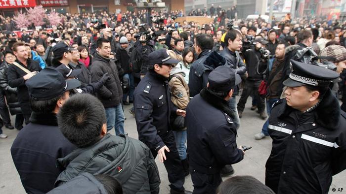 Chinese police officers urge people and journalist to leave an area in front of a McDonald's restaurant which was a planned protest site for "Jasmine Revolution" in Beijing, China, Sunday, Feb. 20, 2011. Jittery Chinese authorities staged a concerted show of force Sunday to squelch a mysterious online call for a "Jasmine Revolution" apparently modeled after pro-democracy demonstrations sweeping the Middle East. (AP Photo/Andy Wong)