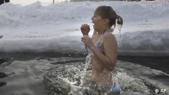 A girl emerges from cold water after plunging into an icy pond to mark the upcoming Epiphany in northwestern Moscow, Tuesday, Jan. 18, 2011. Thousands of Russian Orthodox Church followers plunged Tuesday into icy rivers and ponds across the country to mark the upcoming Epiphany, cleansing themselves with water deemed holy for the day. Water that is blessed by a cleric on Epiphany is considered holy and pure until next year's celebration, and is believed to have special powers of protection and healing. The Russian Orthodox Church follows the old Julian calendar, according to which Epiphany falls on Jan. 19. Moscow temperatures on Tuesday morning dropped to -13 C ( 9 F). (Foto:Mikhail Metzel/AP/dapd)