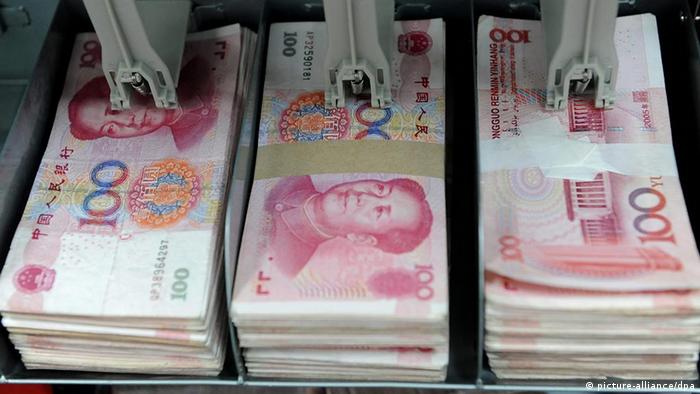 A bank teller counts renminbi bank notes in Shenyang, EPA/MARK