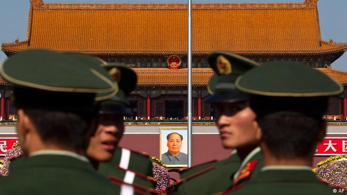 Paramilitary policemen look back while patrolling on the Tiananmen Sqaure in front of the late communist leader Mao Zedong's portrait in Beijing, China, Friday, Oct. 15, 2010. Chinese Communist Party Central Committee meetings open Friday in Beijing, which is expected to approve the economic blueprint for 2011-2015 that will promote policies to close yawning gaps between rich and poor and to encourage consumer spending as a new economic driver. (AP Photo/Alexander F. Yuan)
