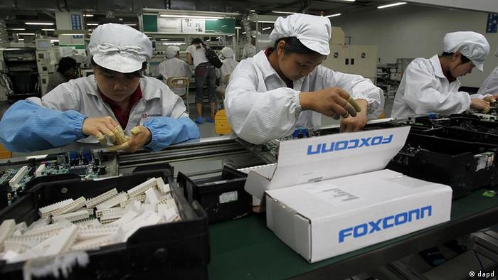 Staff members work on the production line at the Foxconn complex in the southern Chinese city of Shenzhen, Southern city in China, Wednesday, May 26, 2010. The head of the giant electronics company whose main facility in China has been battered by a string of worker suicides opened the plant's gates to scores of reporters Wednesday, hours after saying that intense media attention could make the situation worse. (AP Photo/Kin Cheung)
