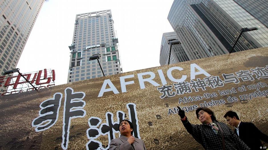 Chinese woman stand in front of a billboard which promotes the upcoming China-Africa summit meeting, outside a hotel in Beijing Thursday Oct. 26, 2006. Beijing is making unusually lavish efforts to welcome leaders and officials from 48 African nations this week for a landmark summit meant to highlight China's huge and growing role in Africa. The Chinese characters at left read Africa. (AP Photo/Greg Baker)