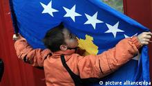 A child kisses Kosovo's flag