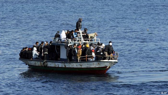 A boatload of would-be migrants believed to be from North Africa is seen moments before being rescued by the Italian Coast Guard in the waters off the Sicilian island of Lampedusa