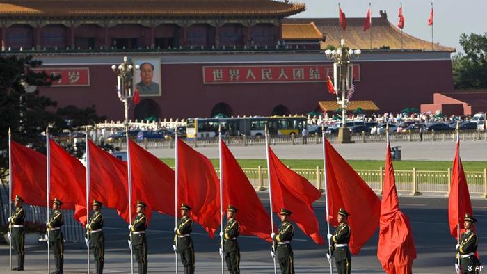 A member of an honor guard is wrapped in a red flag he holds during a welcome ceremony for the visiting Malaysian prime minister near the Tiananmen Square in Beijing Wednesday, June 3, 2009, on the eve of the 20th anniversary of the bloody crackdown on 1989 pro-democracy protests. (AP Photo/Alexander F. Yuan)