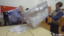 Members of the local electoral commission empty ballot boxes after the close of voting in a polling station in Russia's far-eastern port of Vladivostok
