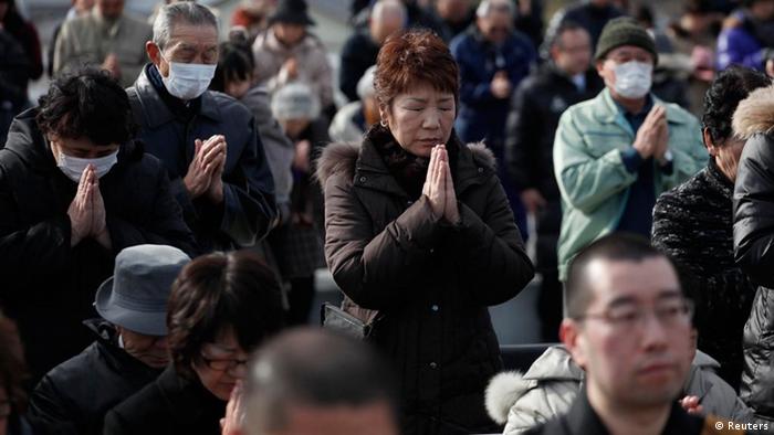 People take part in a moment of silence at 2:46p.m. (0546 GMT) during a ceremony at an area damaged by the March 11, 2011 earthquake and tsunami in Ofunato, Iwate Prefecture, March 11, 2012, to mark the first anniversary of the disaster that killed thousands and set off a nuclear crisis. REUTERS/Carlos Barria (JAPAN - Tags: DISASTER ANNIVERSARY)