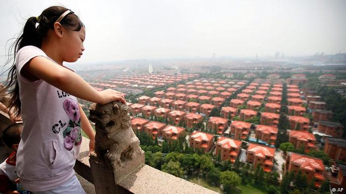 FILE - This Aug. 12, 2009 photo shows a young girl observing the general view of Huaxi, Jiangsu Province, China. Huaxi, though an extreme example, is emblematic of China 60 years after the Communist Party came to power on Oct. 1, 1949. After decades of denouncing free markets and then embracing them, the country is a distinctive patchwork of capitalism with communist characteristics, all anchored by a strong dose of practicality. (ddp images/AP Photo/Eugene Hoshiko) ** zu unserem Korr **