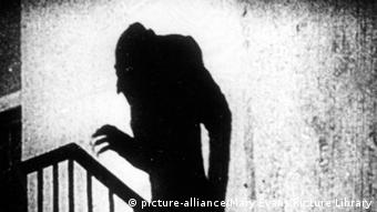 Prikazana je scena iz filma Nosferatu (1922.). Na zidu se vidi sjena vampira koji se penje uz stepenice. 