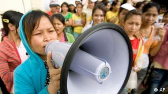 A Cambodian garment worker speaks on a loud speaker as she leads a strike in front of a factory on the outskirts of Phnom Penh, Cambodia, Monday, Sept. 13, 2010. (AP Photo/Heng Sinith)