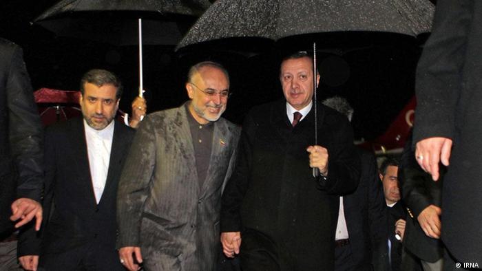 Turkish Prime Minister Tayyip Erdogan (right) sheltering from a rainfall under an umbrella with Iranian Foreign Minister Ali Akbar Salehi 