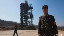 North Korean soldiers stands in front of the country's Unha-3 rocket, slated for liftoff between April 12-16, at Sohae Satellite Station in Tongchang-ri, North Korea on Sunday April 8, 2012. North Korean space officials have moved a long-range rocket into position for this week's controversial satellite launch, vowing Sunday to push ahead with their plans in defiance of international warnings against violating a ban on missile activity. (Foto:David Guttenfelder/AP/dapd)