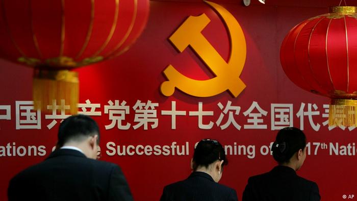 Staff members walk past the communist hammer and sickle emblem at the press center for the 17th National Congress of the Communist Party of China, in Beijing Wednesday Oct. 10, 2007Photo:  (ddp images/AP Photo/Greg Baker)
