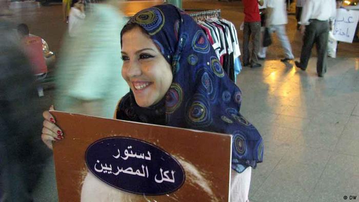 A protester in Cairo carrying a sign "a constitution for all Egyptians"