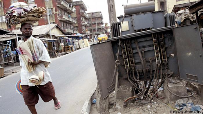 A man walks past a damaged transformer in Lagos, Nigeria. 