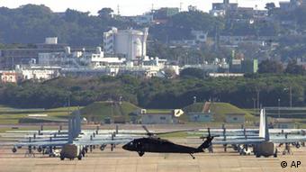 FILE - In this Feb. 12, 2007 file photo, Marine Corps helicopters and transport planes are seen on a tarmac of Futenma Marine Corps Air Station next to residential quarters in Okinawa, Japan. The top American defense official says he expects the U.S. Marine base to remain on Japan's southern island of Okinawa despite political pressure among Tokyo's new leaders to shut it down. U.S. Defense Secretary Robert Gates was to meet Tuesday, Oct. 20, 2009, with Japanese Foreign Minister Katsuya Okada on a visit to Tokyo where the Futenma base was expected to be a top topic. (AP Photo/Itsuo Inouye, File)