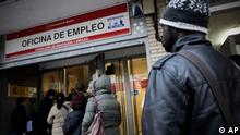 People queue outside an unemployment registry office in Madrid