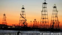 The sun rises behind the oil derricks on the Caspian Sea near Baku, Azerbaijan, Friday 07 October 2005. More than 1,500 floatable oil derricks extract oil from Caspian's seabed in Azerbaijan. In 2005 Azerbaijan extracted 19,5 million tons of oil. Foto: SERGEI ILNITSKY +++(c) dpa - Report+++

