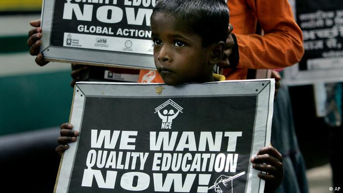 An underprivileged boy holds a banner during a rally saying We want quality education now in India