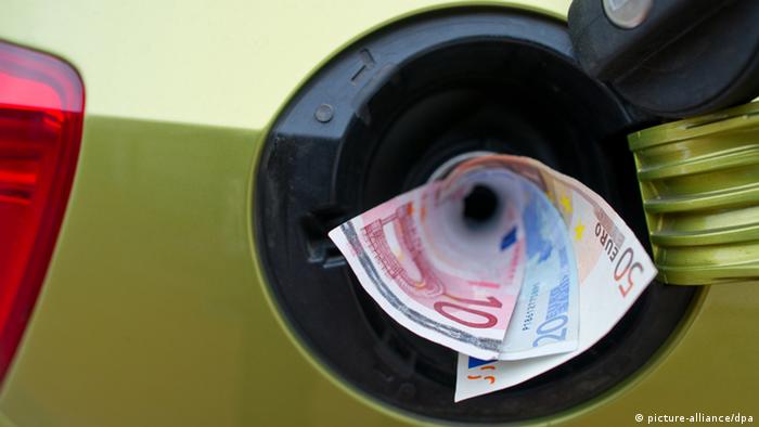 Euro notes coming out of a car's gas tank