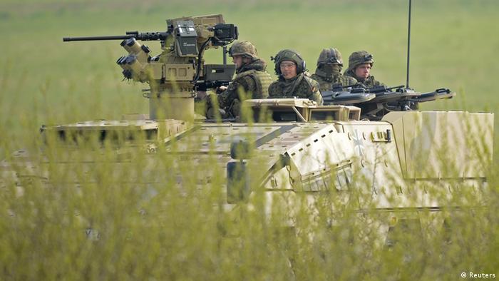 German soldiers sit on a armoured fighting vehicle Boxer during a presentation of German army Bundeswehr in Putlos, northern Germany on April 25, 2012. 