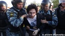 Police officers wearing protective face masks and black kevlar chest pads take pull a thin young man apart from other protestors
(Photo: EPA/MAXIM SHIPENKOV)