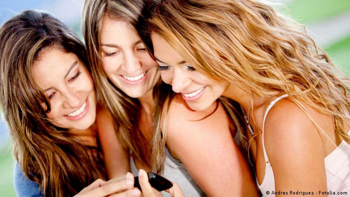 Gossip girls looking at a cell phone and smiling. Fotolia #39035924
Copyright: Andres Rodriguez - Fotolia.com