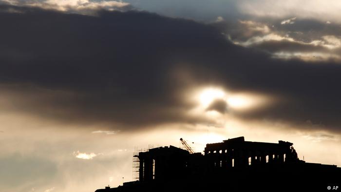 The temple of Parthenon is silhouetted against a cloudy sunset 