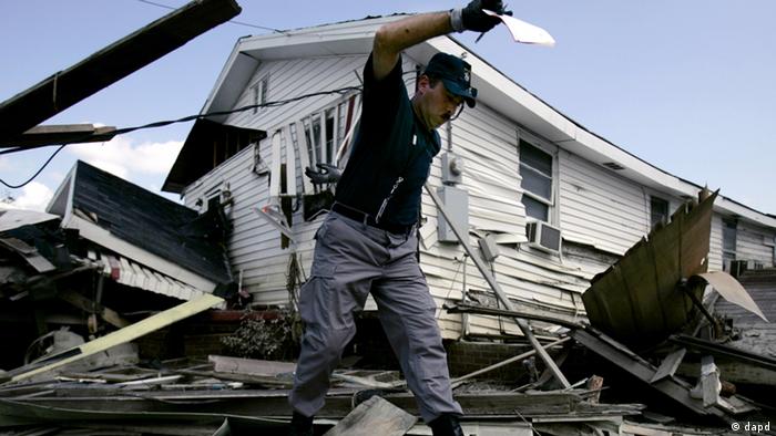Paris, Maine, firefighter Stan Larson tries to keep his balance as he makes his way across debris to place a red sticker on a flood-damaged home in the lower Ninth Ward of New Orleans Saturday, Oct. 1, 2005. (Photo: ddp images/AP Photo/Charlie Riedel)