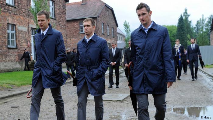 In this photo provided by the German Soccer Federation, DFB, manager Olivier Bierhoff and players Philipp Lahm and Miroslav Klose, from left, tour through the Nazi death camp Auschwitz with the German national soccer team in Oswiecim, southern Poland, Friday, June 1, 2012