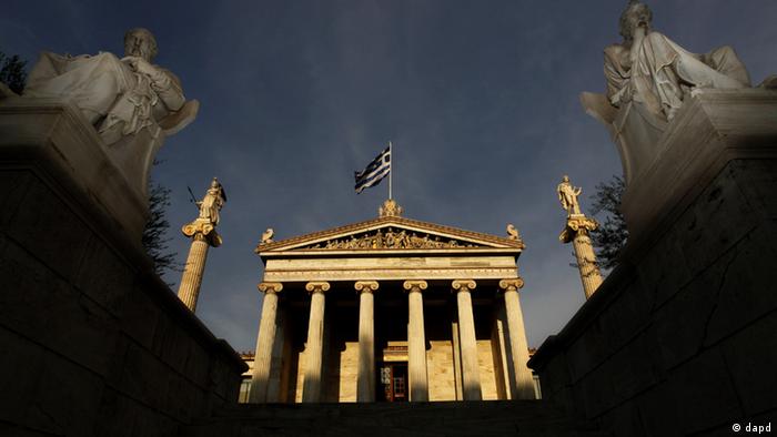 Marble statues of ancient Greek philosophers Socrates, right, and Plato, left, are seen on plinths in front of the Athens Academy, as the Greek flag flies overhead. (Foto: Petros Giannakouris/AP/dapd)