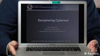 A person holding a laptop computer with the words Decipherine Cyberwar on the monitor
Photo: REUTERS/John Adkisson/Files 
