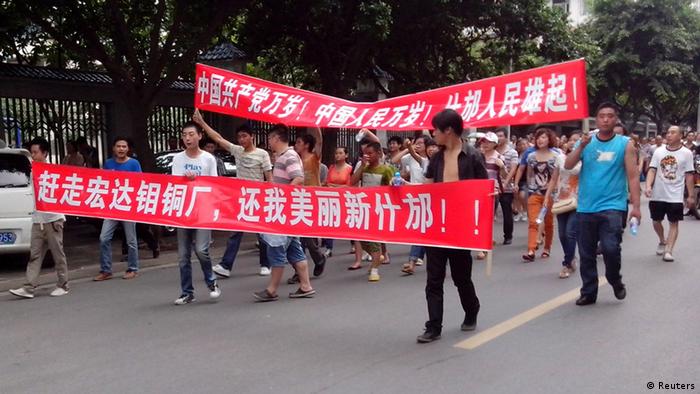 Local residents march with banners during a protest along a street in Shifang, Sichuan province July 3, 2012. Residents in Shifang, a city in southwest China, took to the streets for a third day on Tuesday, demanding the government scrap plans for a copper alloy project they fear will poison them, in the latest unrest spurred by environmental concerns. The Chinese characters on the banners read, "Get rid of Hongda copper alloy project, give me back the beautiful new Shifang" (front) and "Long live the Chinese Communist Party! Long live the Chinese people! Rise up the people of Shifang!" REUTERS/Stringer (CHINA - Tags: ENVIRONMENT POLITICS CIVIL UNREST) CHINA OUT. NO COMMERCIAL OR EDITORIAL SALES IN CHINA