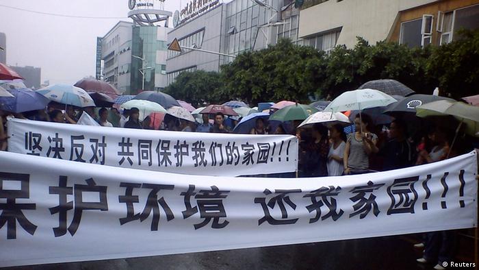 Local residents parade with banners during a protest along a street in Shifang county, Sichuan province in this handout picture taken on July 2, 2012. Shifang, a city in southwest China, has temporarily halted work on a copper alloy project and threatened to punish organisers of a two-day protest against it if they do not give themselves up, in the latest example of unrest spurred by the country's environmental woes. The Chinese characters on the banners read, Protect the environment, Return our homeland!(front) and Stand against it, and stand together to protect our homeland!. Picture taken July 2. REUTERS/Handout (CHINA - Tags: ENVIRONMENT CIVIL UNREST POLITICS) FOR EDITORIAL USE ONLY. NOT FOR SALE FOR MARKETING OR ADVERTISING CAMPAIGNS. CHINA OUT. NO COMMERCIAL OR EDITORIAL SALES IN CHINA