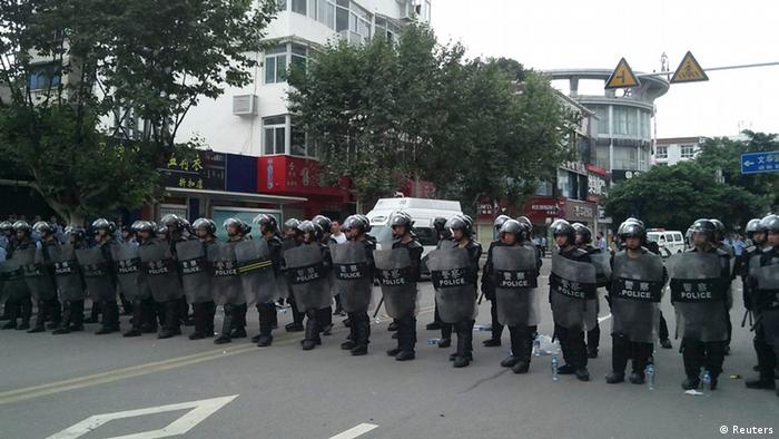 Riot police stand in a line to guard a street during a protest in Shifang, Sichuan province July 3, 2012. Residents in Shifang, a city in southwest China, took to the streets for a third day on Tuesday, demanding the government scrap plans for a copper alloy project they fear will poison them, in the latest unrest spurred by environmental concerns. REUTERS/Stringer (CHINA - Tags: ENVIRONMENT POLITICS CIVIL UNREST) CHINA OUT. NO COMMERCIAL OR EDITORIAL SALES IN CHINA