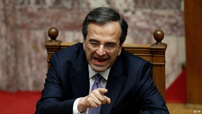 New Greek Prime Minister Antonis Samaras speaks  to a colleague during a policy statement session at the parliament in Athens on Friday, July 6, 2012