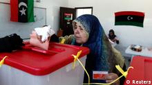 A woman voter drops voting papers inside a ballot box in Sirte July 7, 2012. Libyans queued to vote in their first free national election in 60 years on Saturday, a poll designed to shake off the legacy of Muammar Gaddafi but which risks being hijacked by violence. Libyans will choose a 200-member assembly which will elect a prime minister and cabinet before laying the ground for full parliamentary elections next year under a new constitution. REUTERS/Anis Mili (LIBYA - Tags: POLITICS ELECTIONS)