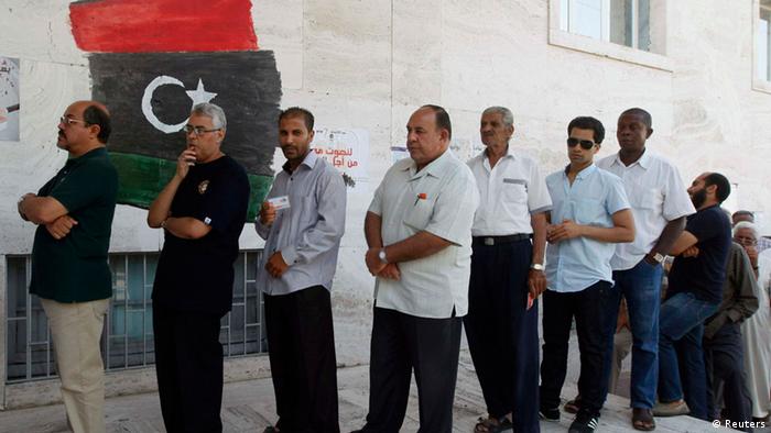 Libyan men queue up to cast their vote outside a polling station in Tripoli July 7, 2012. Libyans began voting in their first free national election in 60 years on Saturday, a poll designed to shake off the legacy of Muammar Gaddafi but which risks being hijacked by autonomy demands in the east and unrest in the desert south. Voters will choose a 200-member assembly which will elect a prime minister and cabinet before laying the ground for full parliamentary elections next year under a new constitution. REUTERS/Ismail Zitouny (LIBYA - Tags: POLITICS ELECTIONS)