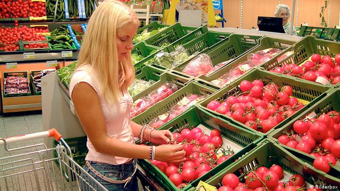 Woman purchasing fruit and vegetables from a supermarket (Photo: dpa/DW)