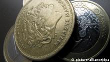 ILLUSTRATION - Eine Münze der ehemaligen griechischen Währung "Drachme", aufgenommen am 25.06.2012 in München vor Ein-Euro-Münzen. Foto: Stephan Jansen dpa/lby
