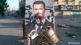 A defaced poster of Syria's President Bashar al-Assad