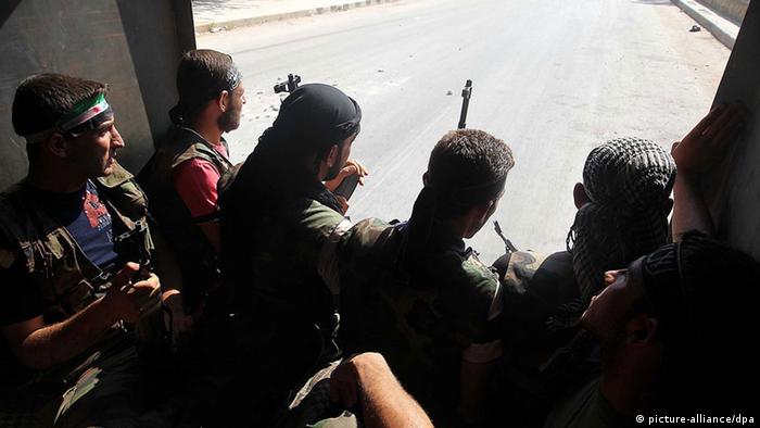 Syrian rebels patrol near Aleppo, Syria, 26 July 2012. 