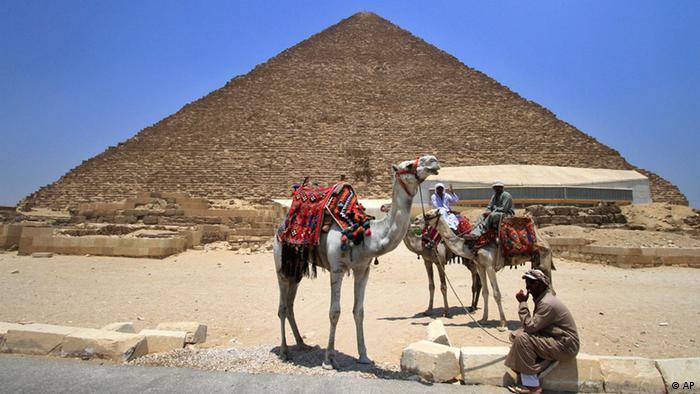 Tourists guides sit on camels as they wait for clients next to the Giza pyramids on the outskirts of Cairo, Egypt, Thursday, June 23, 2011. (ddp images/AP Photo/Khalil Hamra)
