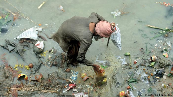 A man tries to collect garbage in a polluted Ganges (photo: pixel)