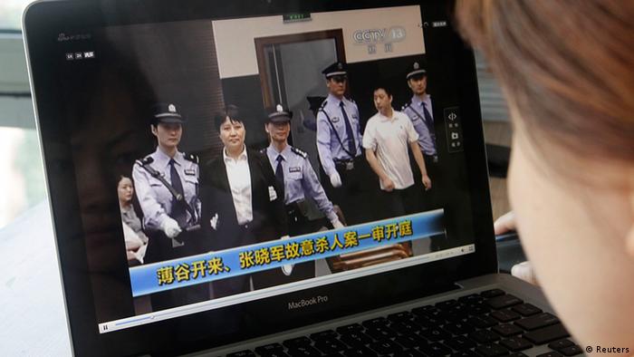 A woman watches a CCTV video showing Gu Kailai being escorted into the court room for trial at Hefei Intermediate People's Court, on a laptop in Beijing August 9, 2012. Gu Kailai, the wife of ousted Chinese Communist Party Politburo member Bo Xilai, did not raise objections in court on Thursday to charges against her of murdering a British businessman, a court official said. REUTERS/Jason Lee (CHINA - Tags: POLITICS CRIME LAW TPX IMAGES OF THE DAY)